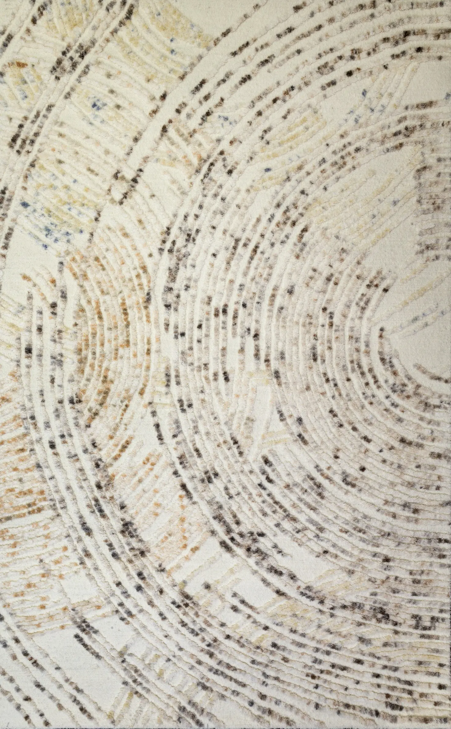 Close-up of a textured textile with cream and beige circular, spiral stitch patterns and brown specks on a soft background.