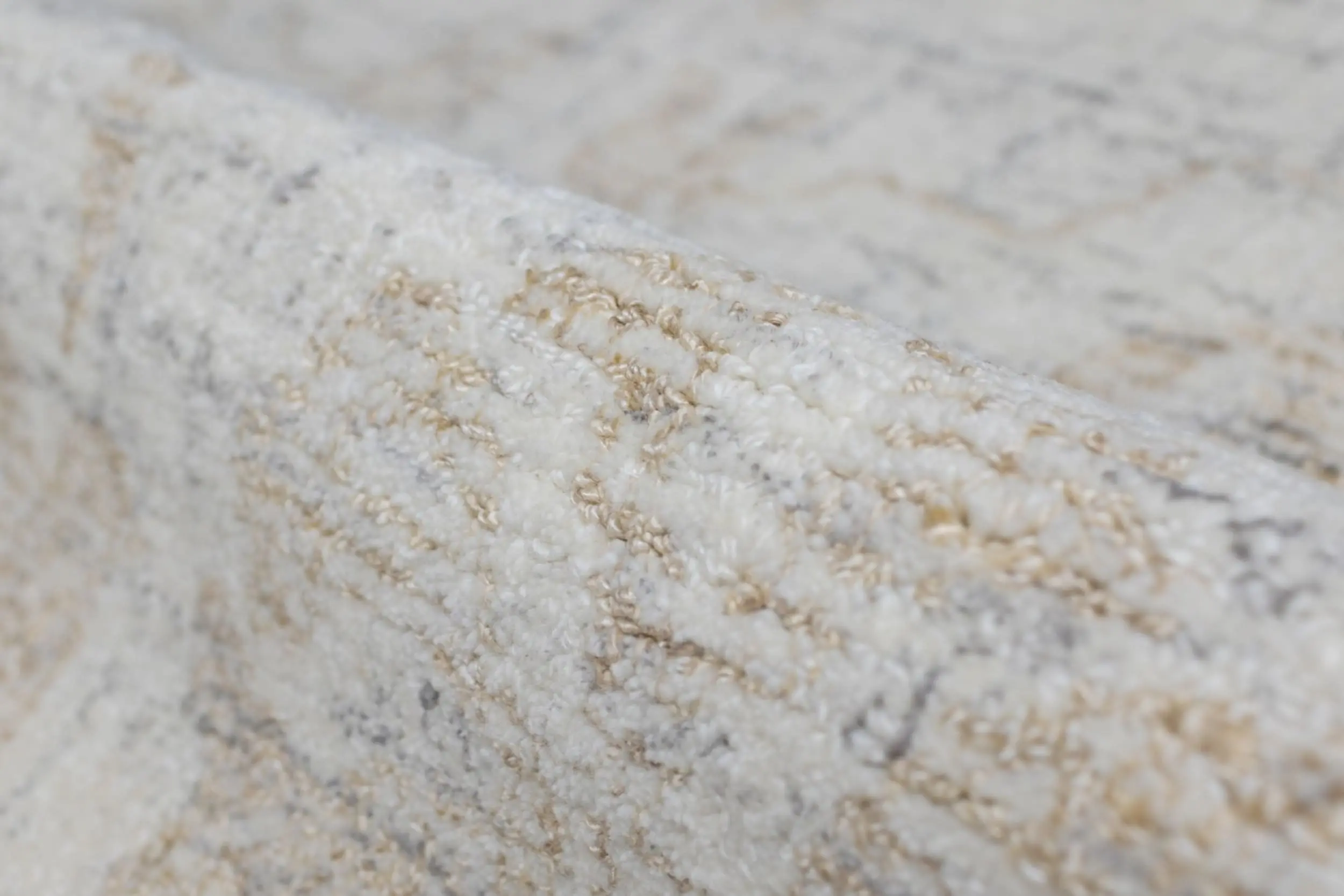 Close-up of a pale, textured stone surface with white and beige mineral veining.