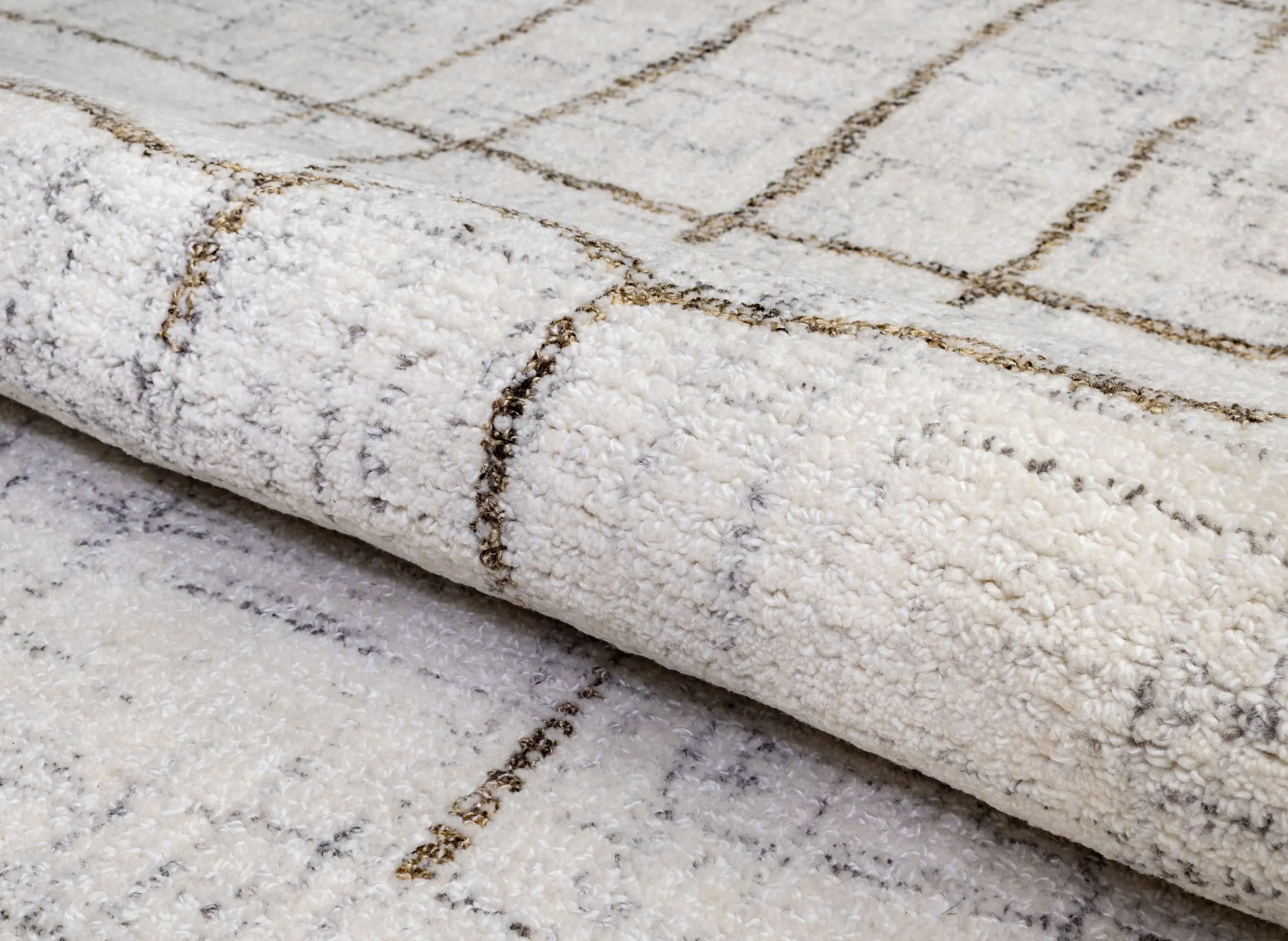 Close-up of a white fluffy rug showing a brown grid pattern outline across the surface